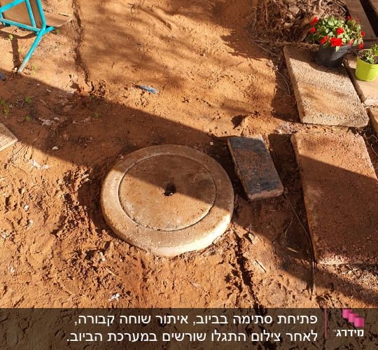 מכסה ביוב עגול על אדמה חומה